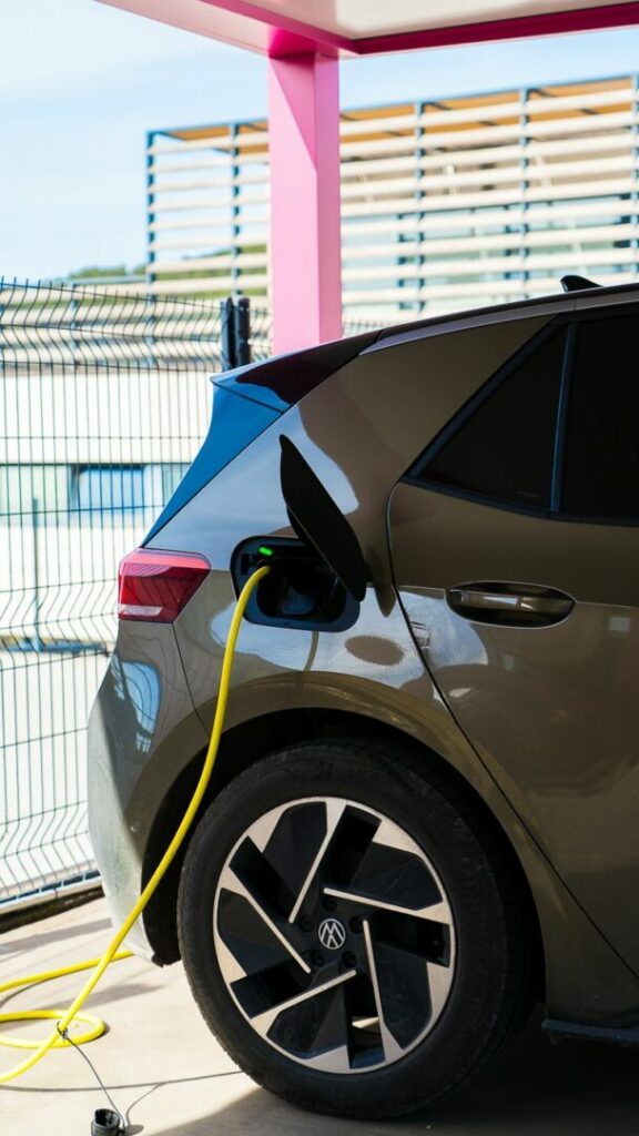 Voiture électrique en recharge sous le carport solaire du siège Izitek à Éguilles